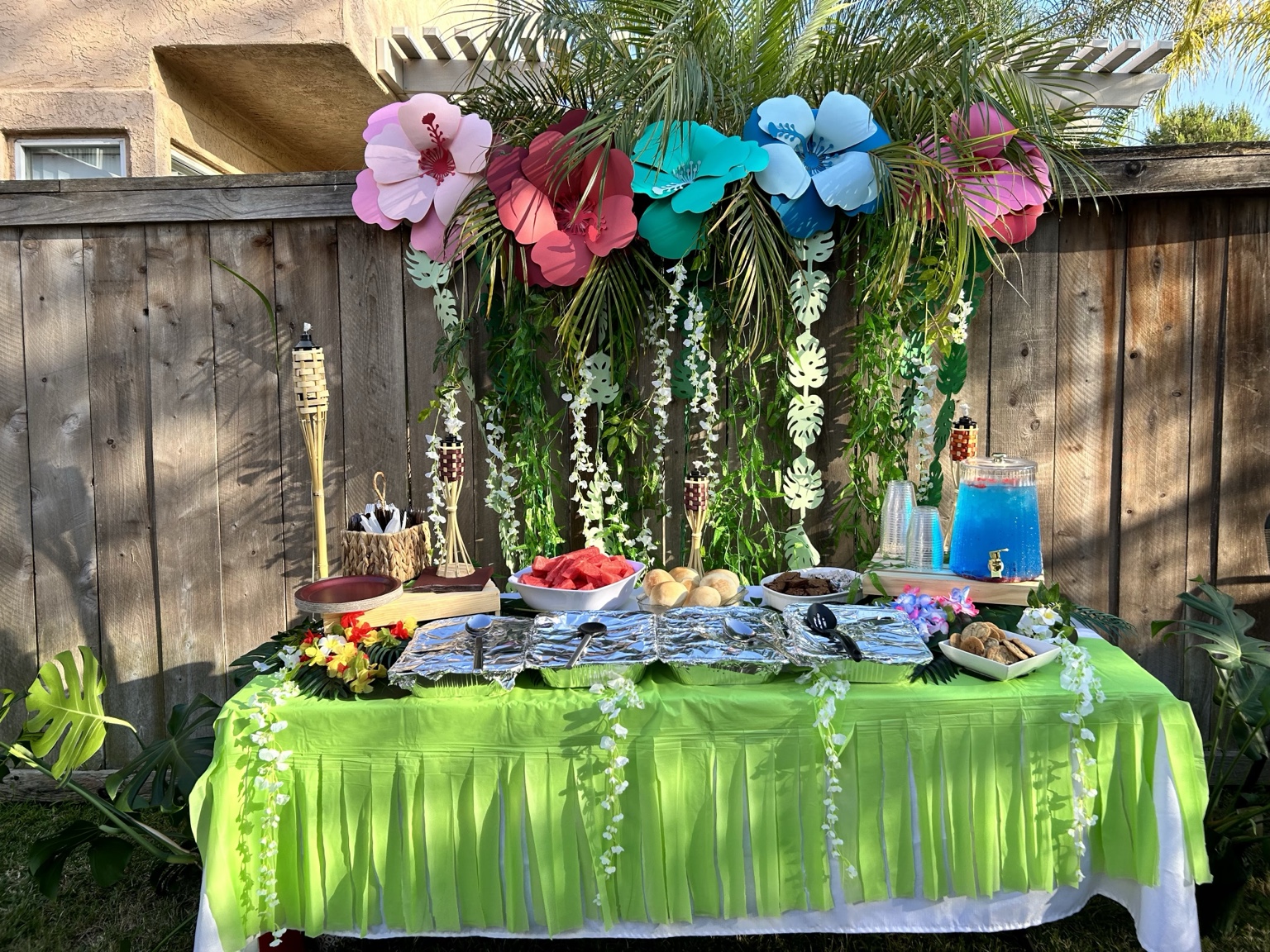 Tropical buffet table with floral backdrop