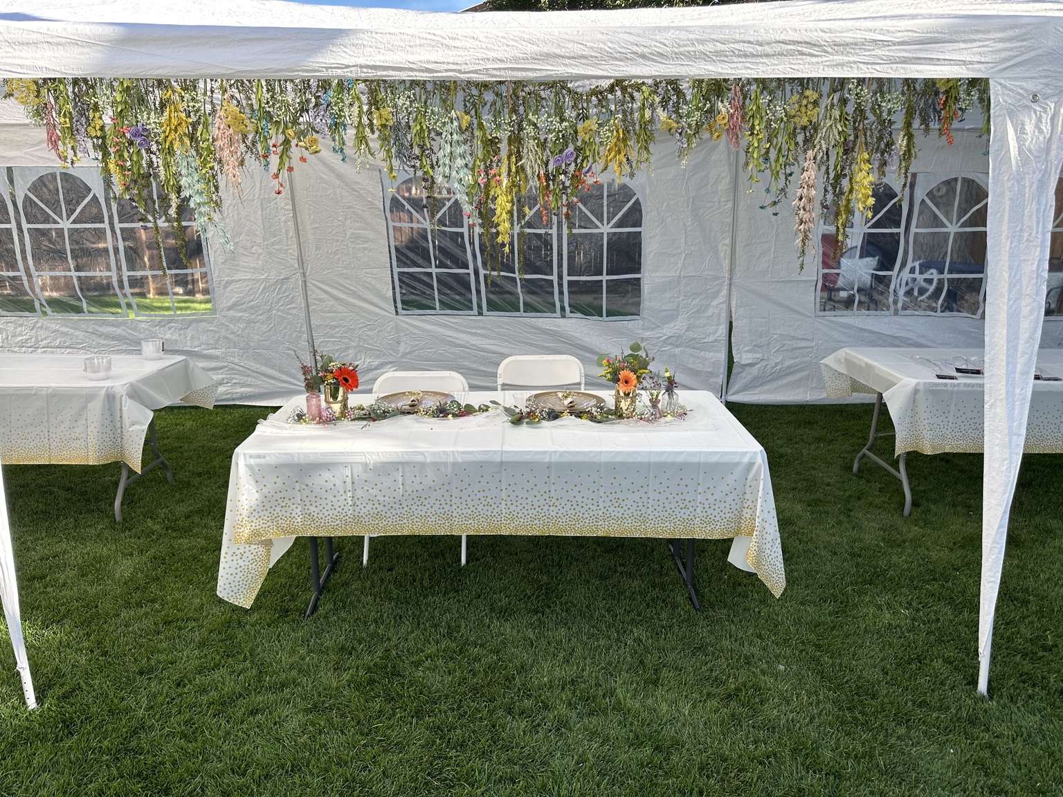 Floral sweetheart table beneath a hanging garden installation